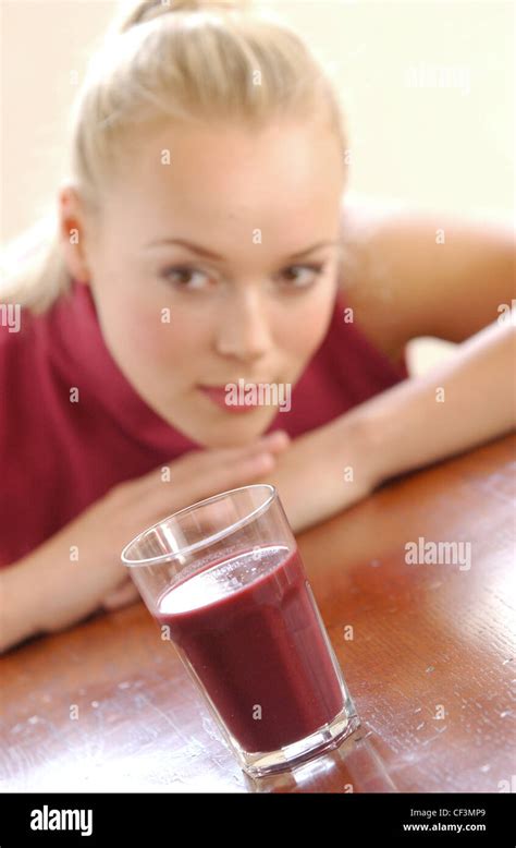 out of focus female blonde hair up off face wearing red polo neck tank