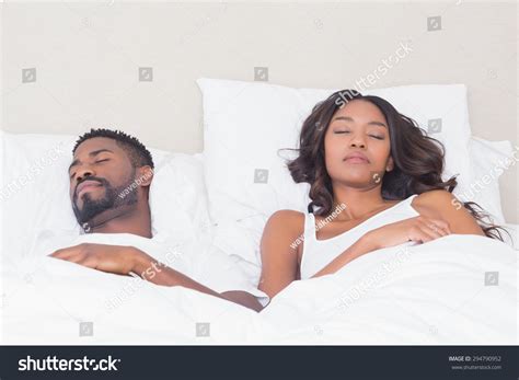 Happy Couple Sleeping In Bed Together At Home In Bedroom