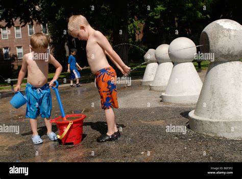 zwei nackten oberkörper jungen genießen spielplatz sprinkler an einem