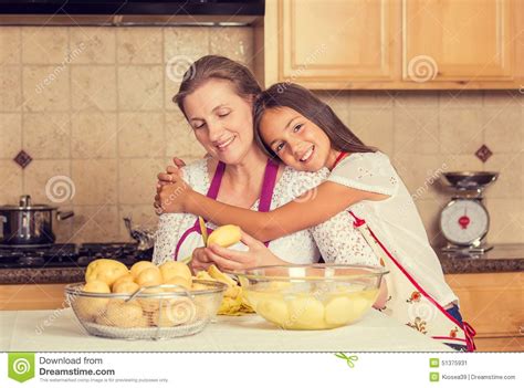 happy smiling mother and daughter cooking dinner