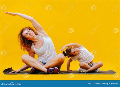 Mom And Daughter Synchronously Do Exercise Tilts To The Side Stock