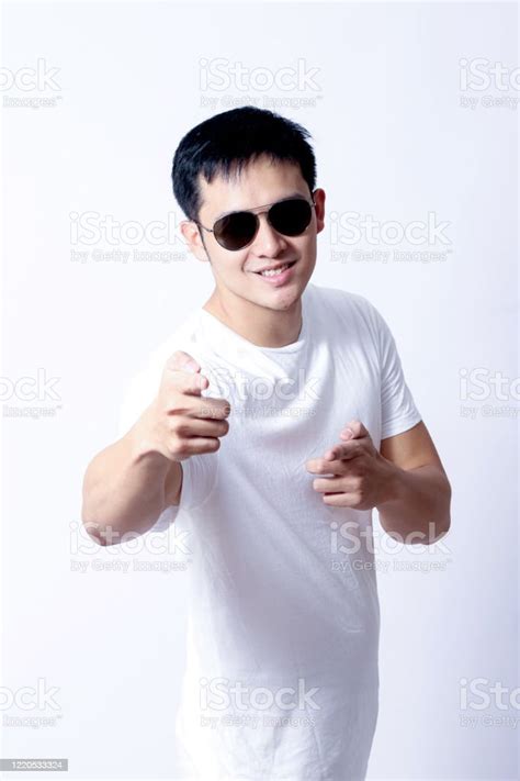 녹색 티셔츠와 흰색 청바지를 입고 제스처 기호 또는 장치를 보여주는 젊은 아시아인의 초상화 T 셔츠에 대한 스톡 사진 및 기타