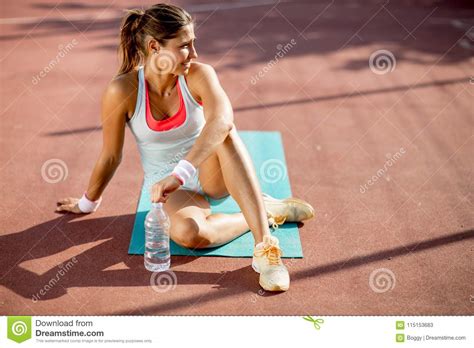 Sporty Young Woman Relaxing And Drinking Water After Training Stock