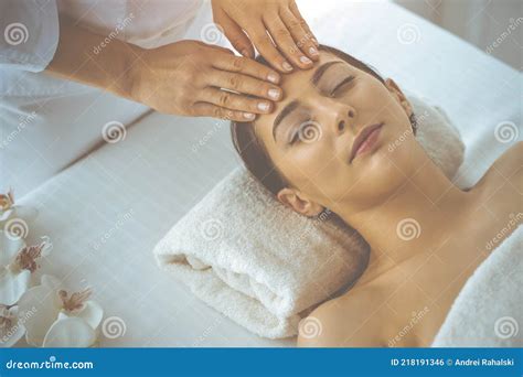 beautiful brunette woman enjoying facial massage  closed eyes