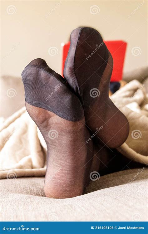 a portrait of a womanand x27 s feet wearing black nylon stockings or