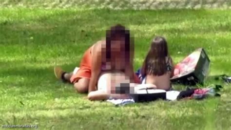 una pareja tiene sexo en un parque al lado de una niña