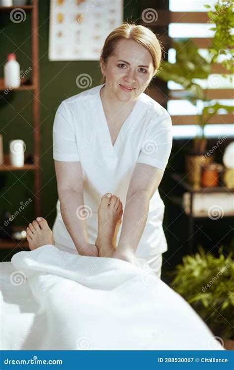 Massage Therapist In Massage Cabinet Massaging Clients Leg Stock Image