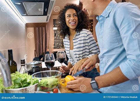Young Adult Wife And Husband Smiling Cooking Dinner On Kitchen Stock