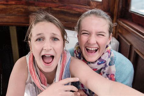 two teen girls laughing together by stocksy contributor gillian vann