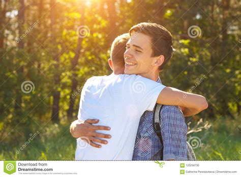 Two Guys Friends Hugging When Meeting The Concept Of