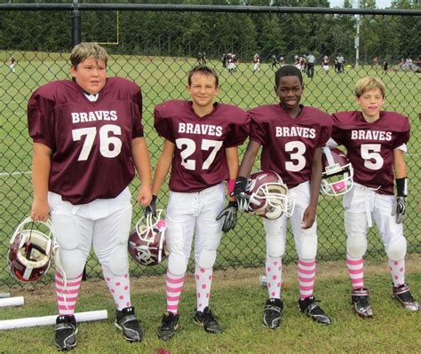 youth football players  pink  honor cancer survivor