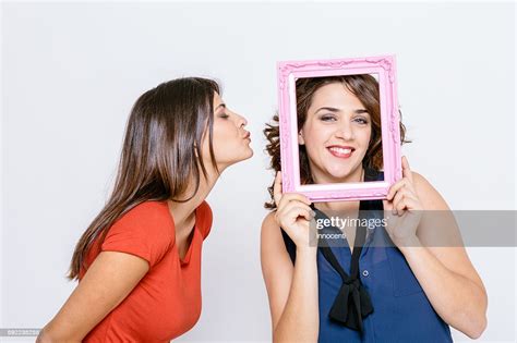 Lesbian Couple Fooling Around With Pink Picture Frame Smiling Puckering