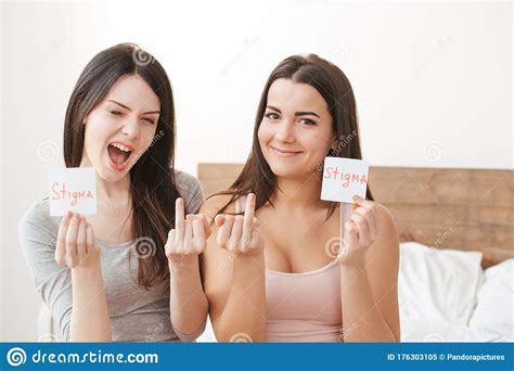 lesbian couple in bedroom at home sitting holding paper