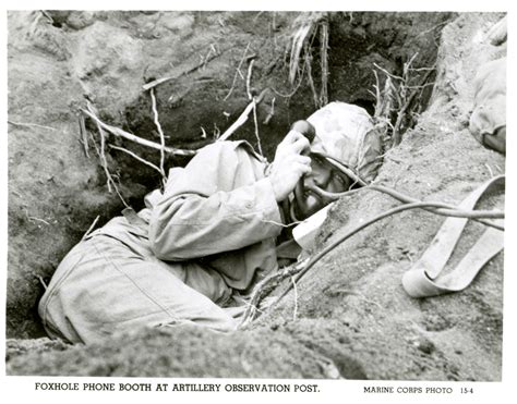 us marine speaking into field phone from small foxhole on