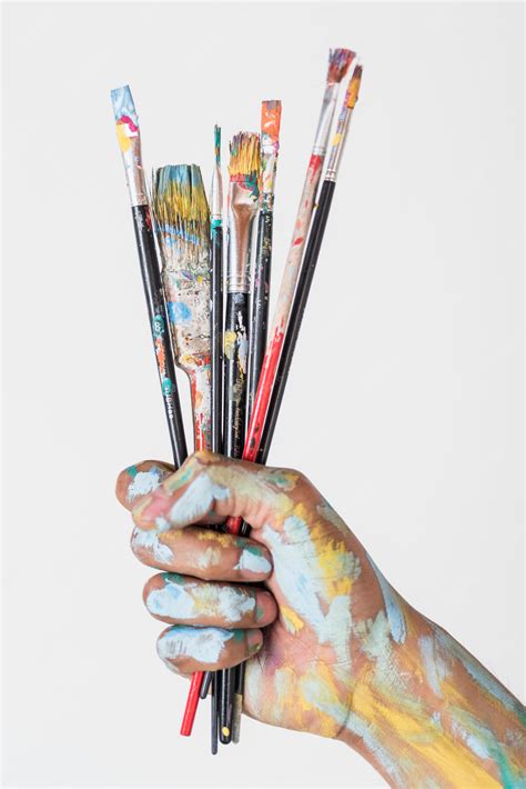 premium photo hand holding brushes stained  paint