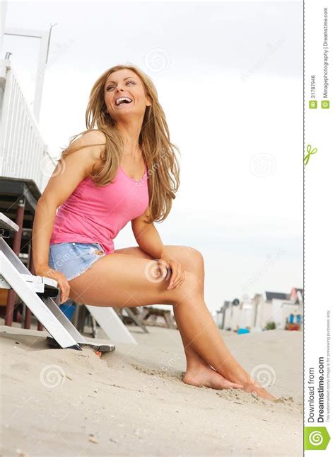 beautiful blond woman laughing at the beach royalty free