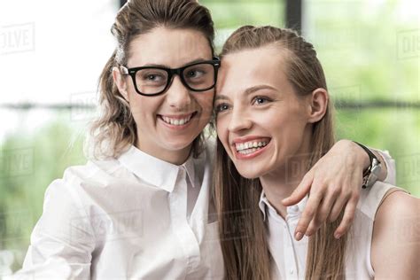 Portrait Of Happy Lesbian Couple Hugging Each Other And Looking Aside