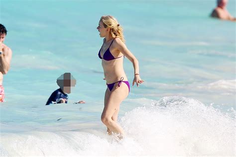naomi watts shows pokies wearing a purple bikini on a beach in st