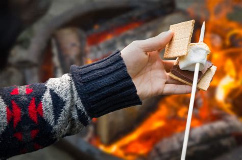 closeup  hands building smore  roasted marshmallow  chocolate  campfire outdoors