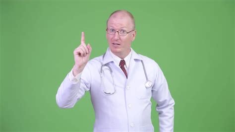 Happy Mature Bald Man Doctor Pointing Finger Up By