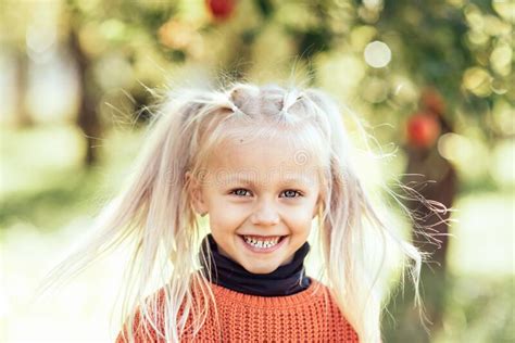 Portrait Of Sweet Little Blonde Girl Playing In Sun Outdoors Stock