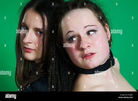 Two Lesbian Sexy Gothic Women With Dreads Wearing Bdsm Outfit On Green