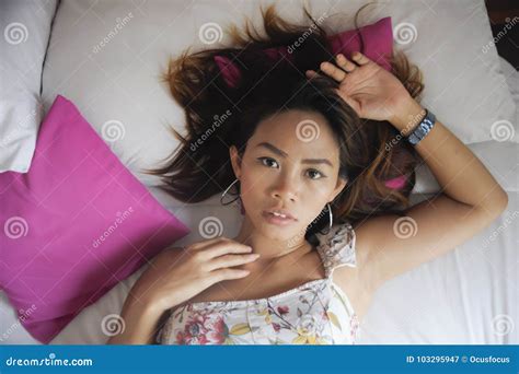 Portrait Of Young Attractive And Beautiful Asian Woman Lying On Bed At