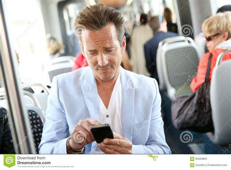 uomo maturo che prende trasporto pubblico facendo uso dello smartphone