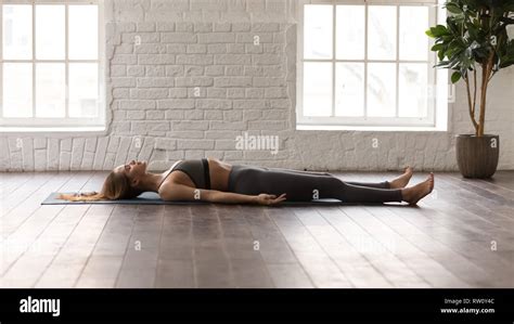 woman practicing yoga lying  savasana dead body pose stock photo