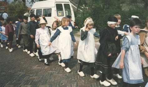 schoolkinderen  heel oude kleding en meestal op klompen lopen mee  een optocht tijdens de