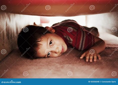 kid hiding  bed stock photo image  funny relaxation