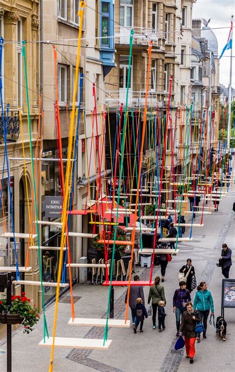 colorful swing installation hangs   luxembourg street urban art installation