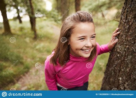 pre teen girl taking a break leaning on tree during a hike in a forest elevated view close up