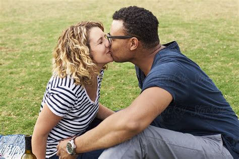 interracial couple kissing in a park by protonic ltd date kiss