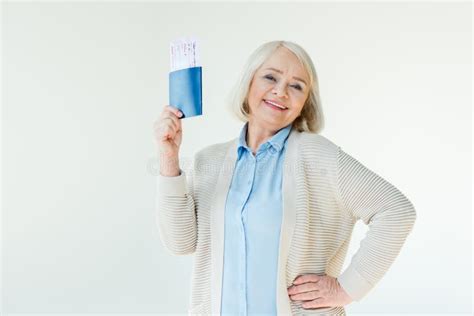 smiling senior woman holding passports and tickets traveling concept
