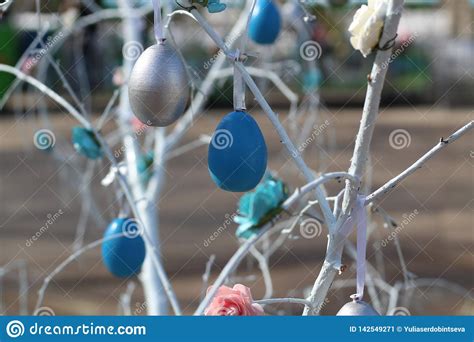 vibrant easter eggs hanging   branches   tree closeup