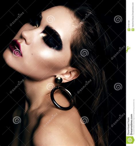 beautiful woman with dark hair and extravagant black smokey eyes makeup