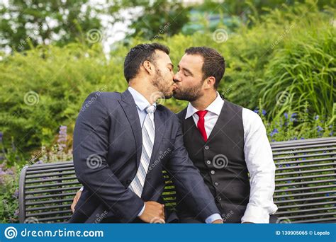 a handsome gay male couple in the park on their wedding