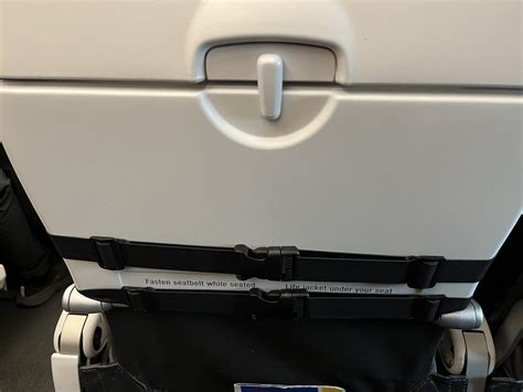 woman  front   put  seat attachment  prevents   opening  tray table