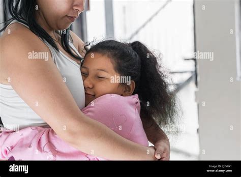 Beautiful Brown Skinned Latina Girl With Her Face Pressed To Her Mother