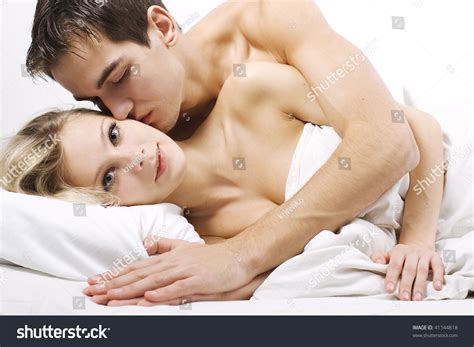 Loving Affectionate Nude Heterosexual Couple On Bed In