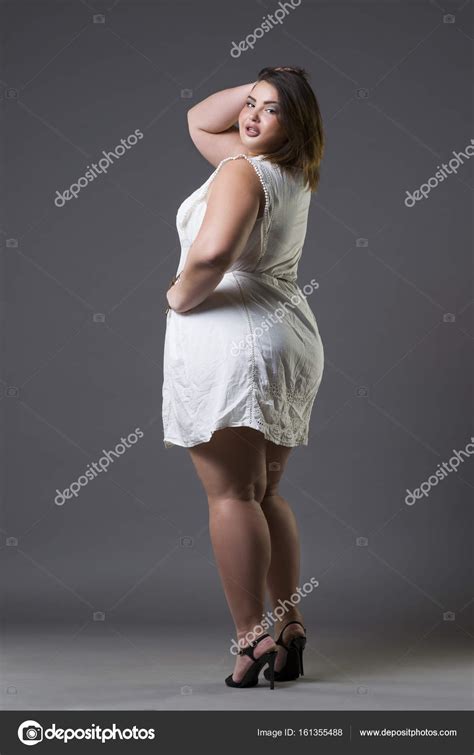 happy plus size fashion model in casual clothes fat woman on gray