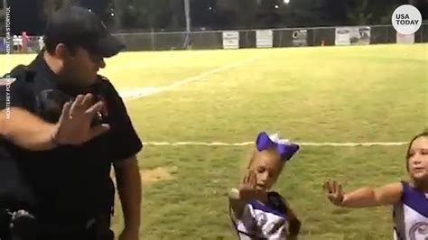 police officer learns cheer routine from tiny cheerleaders during