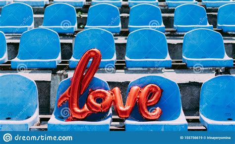 love red foil balloon on blue stadium seats letter shaped balloons