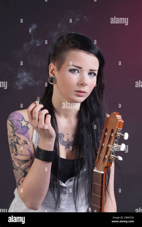 tattooed dark teen girl is smoking and having acoustic