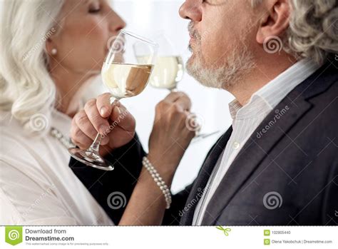 affectionate mature man and woman enjoying alcohol drink together stock