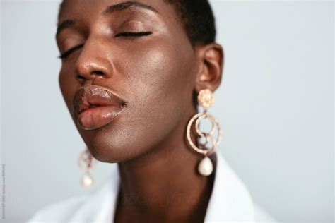 black woman with plump lips and eyes closed by stocksy contributor