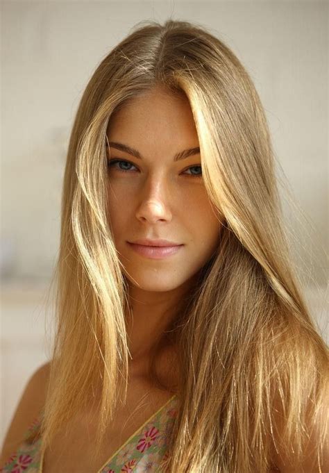 a woman with long blonde hair is posing for the camera and looking at