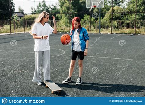 Two Friends Are Learning To Skate The Girls Help Each Other And