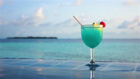 cocktail in a glass with a tubule against blue water sex on the beach stock footage video